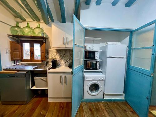 a kitchen with a refrigerator and a washing machine at Riojania Heredad in Santa Eulalia Bajera