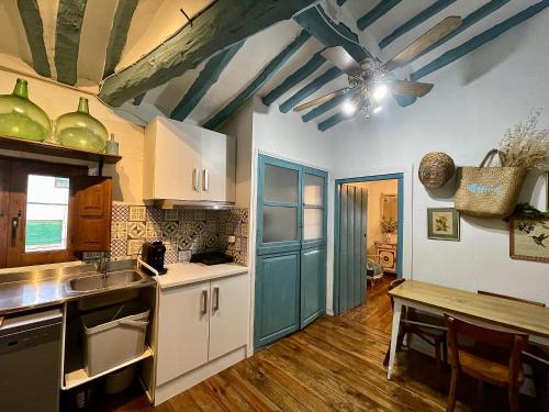 a kitchen with white cabinets and a blue ceiling at Riojania Heredad in Santa Eulalia Bajera