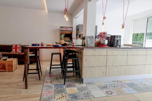 a kitchen with a counter and a table with stools at Appartement design & confort- Route des hôtels in Le Gosier