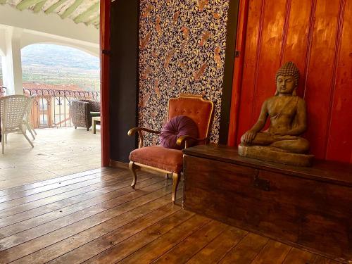 a room with a statue on a dresser and a chair at Riojania Heredad in Santa Eulalia Bajera