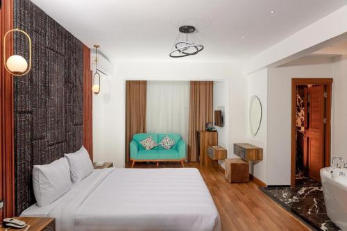 a bedroom with a white bed and a blue chair at La Veranda Pyramids Boutique Hotel in Cairo