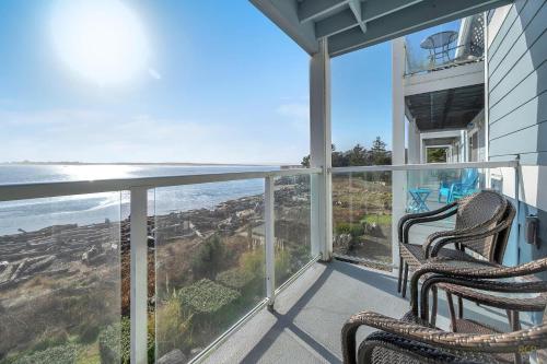 two chairs on a balcony with a view of the ocean at Waters Edge 308 in Lincoln City