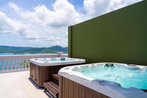 a jacuzzi tub on a balcony with a view at 360 Splendor Del Pacifico Residences in Playa Flamingo