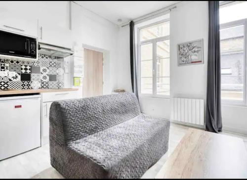 un salon avec une chaise et une cuisine dans l'établissement Basilique IX, à Douvres-la-Délivrande