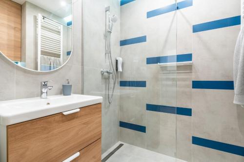 un baño con lavabo y ducha en Parkcity Centrum, en Katowice