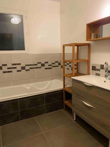 une salle de bain avec une baignoire et un lavabo dans l'établissement Villa bord de mer au Grau d 'Agde 140 m2, au Grau-dʼAgde