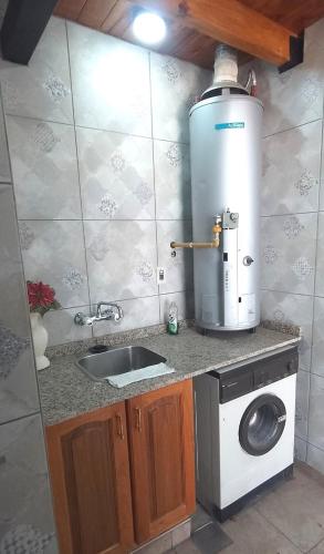 a kitchen with a sink and a washing machine at Casa confortable con muy buena ubicación in Las Heras