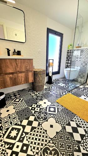 a bathroom with a black and white tiled floor with a tub at Magic view in Sveti Filip i Jakov