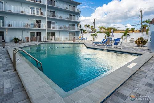 ein Schwimmbad vor einem Gebäude in der Unterkunft Stunning Ocean Views STEPS from the Beach with Pool! Fabulous 4th Floor Studio! in New Smyrna Beach