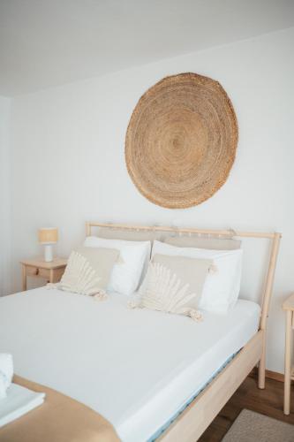 a bed with white pillows and a hat on the wall at Guesthouse Tamara in Lovište