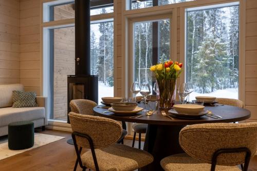 a dining room with a table with flowers and chairs at Villa Vuollo in Äkäslompolo