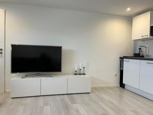 a living room with a flat screen tv on a white cabinet at Souterrain Wohnung in Vellmar bei Kassel in Vellmar
