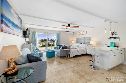 a living room with a couch and a table at Spectacular Ocean View STEPS from the Beach and Pool! Third Floor Studio! in Edgewater