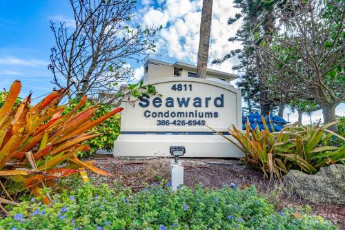 a sign for a seaward communities sign with plants at Beachfront 4th Floor Condo with Spectacular Beach & Ocean Views and Pool! in Bottle Island