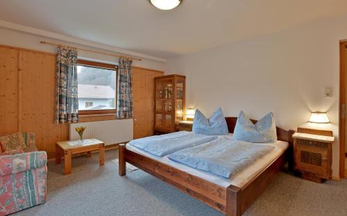 a bedroom with a bed and a couch and a window at Landhaus Fuchs in Walchsee