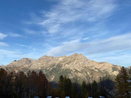 a view of a mountain range with trees in the foreground at Superbe appartement avec balcon in Puy-Saint-Vincent