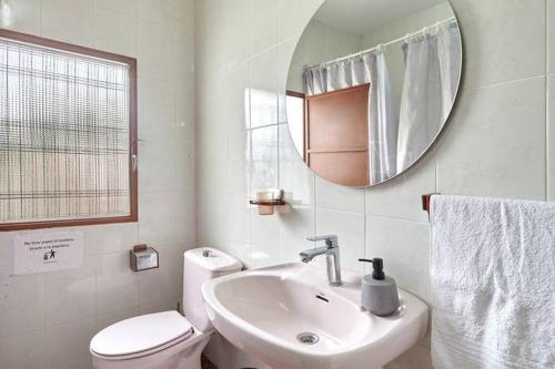 a bathroom with a sink and a toilet and a mirror at la encina in Jaén