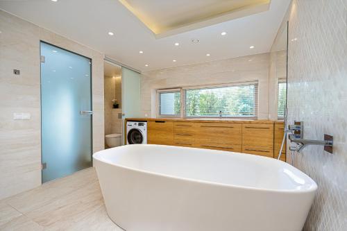 a large white bath tub in a bathroom at Magnolia House with Indoor Swimming Pool and Sauna in Tallinn