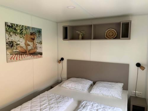 a bedroom with a bed and two pictures on the wall at Chalet in Domburg near Dunes in Koudekerke