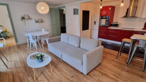 un salon et une cuisine avec un canapé et une table dans l'établissement Grand logement pour 10 - Proche Halles, à Pau