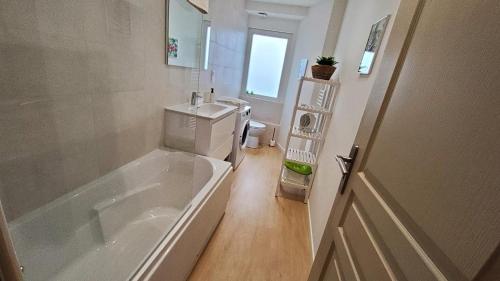 une salle de bain blanche avec une baignoire et un lavabo dans l'établissement Grand logement pour 10 - Proche Halles, à Pau