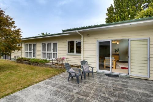 a house with two chairs and a patio at Mid Century Oasis - Hastings Holiday Home in Hastings