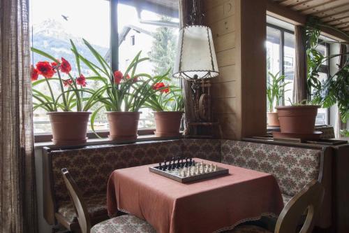 a dining room with a table and a window with flowers at Appartements Christophorus in Bad Hofgastein