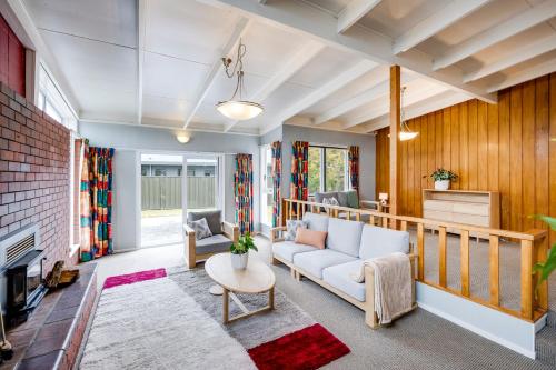 a living room with a couch and a fireplace at Mid Century Oasis - Hastings Holiday Home in Hastings