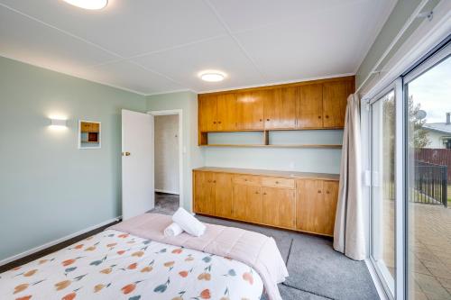 a bedroom with a bed and a window at Mid Century Oasis - Hastings Holiday Home in Hastings