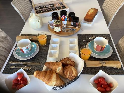 een ontbijttafel met croissants, koffie en jus d'orange bij Les Etoiles de Calès - chambres d'hôtes de charme près de Rocamadour au coeur du Parc Naturel des Causses du Quercy in Calès