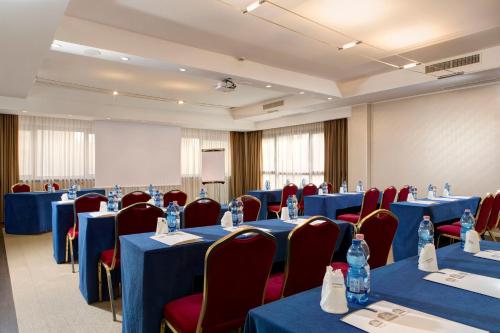 a conference room with blue tables and red chairs at Best Western Plus Tower Hotel Bologna in Bologna