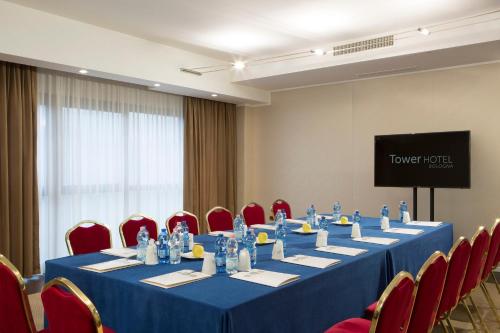 a meeting room with a long table and red chairs at Best Western Plus Tower Hotel Bologna in Bologna