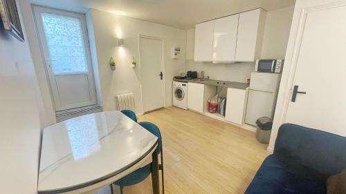 cocina pequeña con mesa blanca y comedor en Apmt BelleVille, en París