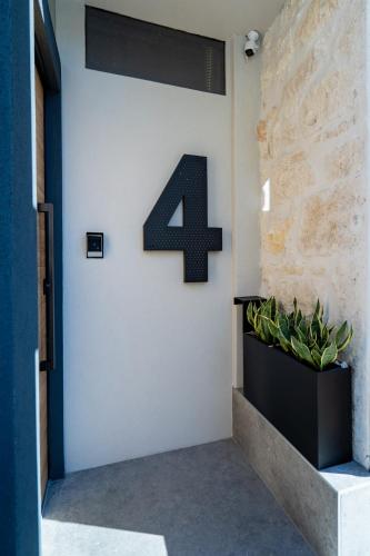 a number four on a wall with a plant at Urban Hive 2-story suite with roof garden in Heraklion