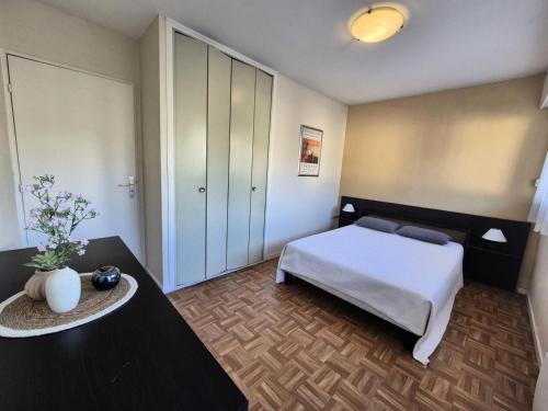 - une chambre avec un lit et 2 tables dans l'établissement Résidence Saint Christophe - Logement traversant, agréable et lumineux à 2 pas de la cure ! MAE-7244, à Aix-les-Bains