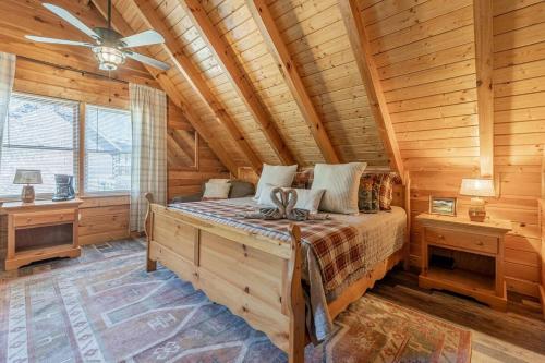 ein Schlafzimmer mit einem Bett in einer Blockhütte in der Unterkunft Cozy Spacious Cabin with Hot Tub, BBQ near Parkway in Pigeon Forge