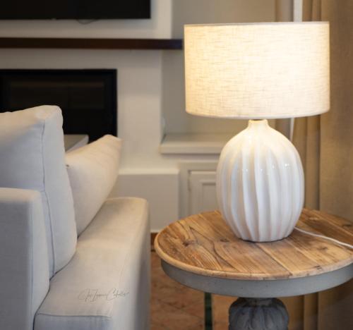 a white lamp on a table next to a couch at El Trastero Suite in Montellano