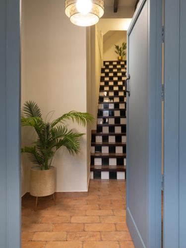 a hallway with a staircase with a potted plant at El Trastero Suite in Montellano