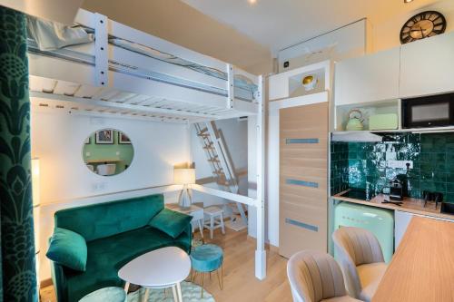 - un salon avec un canapé vert et des lits superposés dans l'établissement La Cabane atypique de la Gare Matabiau, à Toulouse