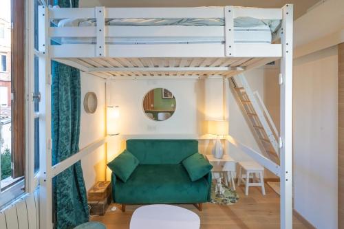 Cette chambre comprend un canapé vert et des lits superposés. dans l'établissement La Cabane atypique de la Gare Matabiau, à Toulouse