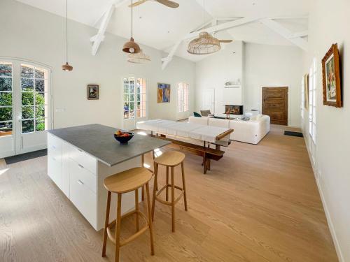 - une cuisine et un salon avec une table et des tabourets dans l'établissement Grande maison de famille rénovée, vue sur Sainte Victoire, à Venelles