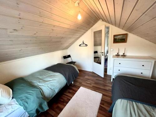 a bedroom with two beds in a attic at Coastal gem with beach, wooden sauna & canoes in Bjästa