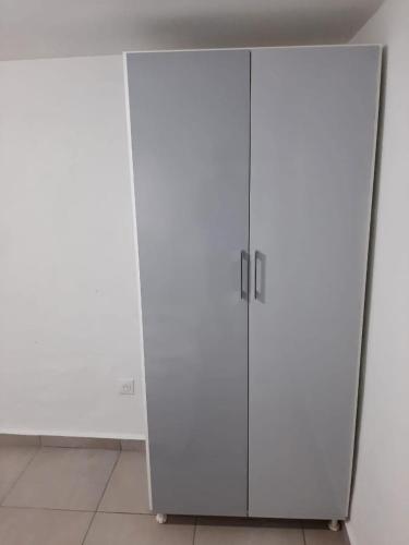a white cabinet with two doors in a room at KARENGA Appartel in Sainte-Anne