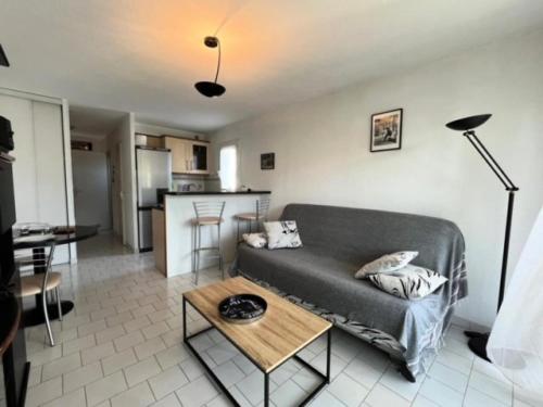 un salon avec un canapé et une table dans l'établissement Résidence Camargue Village - Appartement proche plage au Boucanet MAE-5371, au Grau-du-Roi