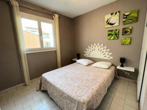 une chambre avec un lit et une fenêtre dans l'établissement Résidence Camargue Village - Appartement proche plage au Boucanet MAE-5371, au Grau-du-Roi