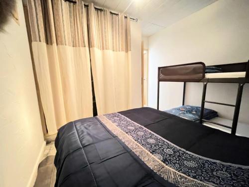 - une petite chambre avec un lit et un rideau dans l'établissement Résidence Le Clamador - Charmant T2 rénové au Grau du roi MAE-5381, au Grau-du-Roi