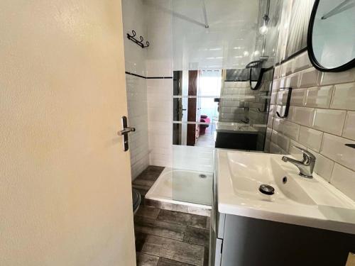 une salle de bain blanche avec un lavabo et une douche dans l'établissement Résidence Le Clamador - Charmant T2 rénové au Grau du roi MAE-5381, au Grau-du-Roi