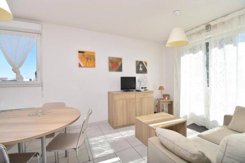 un salon avec une table et une salle à manger dans l'établissement Résidence Cap Camargue - Un sympathique appartement dans une résidence avec piscine MAE-5391, au Grau-du-Roi