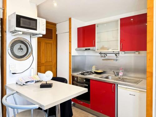 une petite cuisine avec des armoires rouges et un évier dans l'établissement Résidence Le Catamaran - Charmant studio proche plage au grau du roi MAE-5401, au Grau-du-Roi