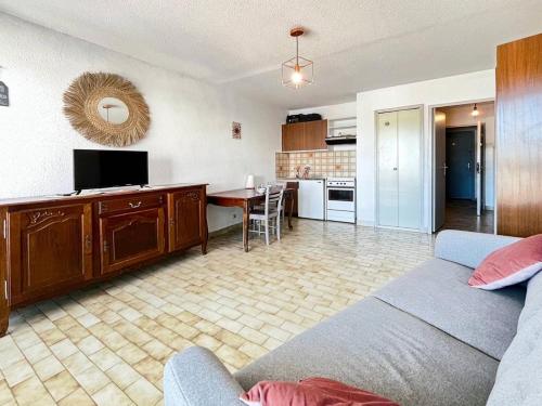 un salon avec un canapé et une table et une cuisine dans l'établissement Résidence La Croisière - T2 proche plage MAE-5421, au Grau-du-Roi